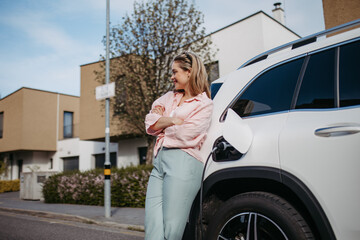 Young woman charging her electric car in home, sustainable and economic transportation concept.