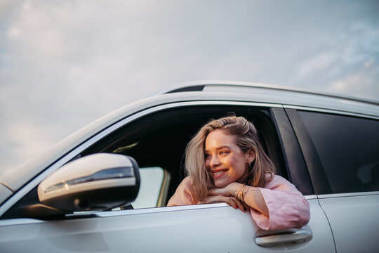 Happy woman driving her new electric car.