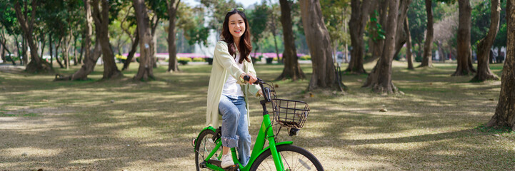 Fototapeta na wymiar Women riding bicycle with having fun to relaxation and exercise for healthy lifestyle in the park