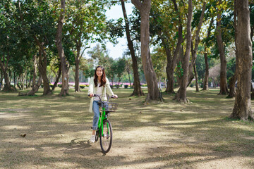 Naklejka premium Women riding bicycle with having fun to relaxation and exercise for healthy lifestyle in the park