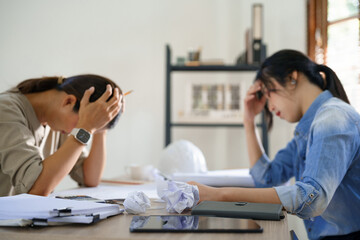 Concept of engineering consulting, Two engineers stressful while sketching blueprint of new project