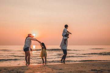 Fototapeta na wymiar Happy asian family that enjoys beach activities during the summer holidays.