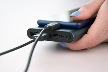 Power bank for charging mobile devices. Black smart phone charger with power bank.