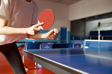 Closeup view of adult woman playing table tennis in gym