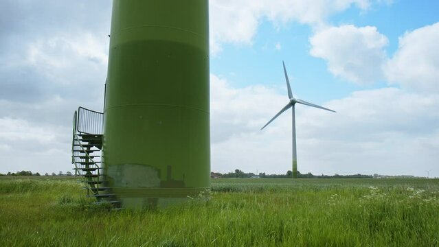 Entrance to a Wind Turbines in foreground and another Wind Turbine on a field in background in East Frisia on a windy summer day in 2023