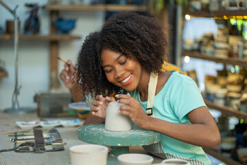 Young woman create clay and ceramic art dishes in pottery workshop