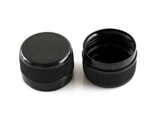 Two new black plastic caps on a white background. High dense plastic caps for plastic bottles. Circle screw lid for drink containers. Waste recycling concept.