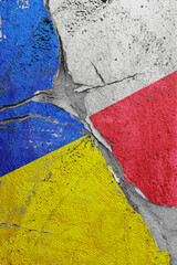 Ukraine and Poland flags on a stone wall with a crack, illustration of the concept of a global crisis in political and economic relations