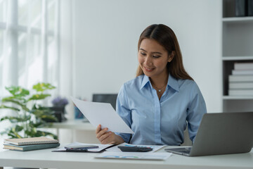 Businesswoman using a laptop computer with documents Calculator, notebook, on the table, planning, analyzing financial reports. business plan investment financial analysis concept