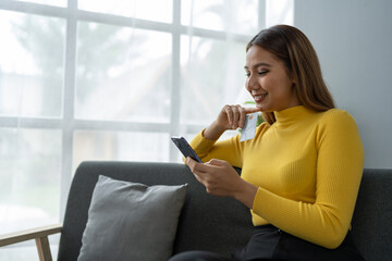 Asian businesswoman shopping online on mobile with credit card for convenient spending at home on vacation, online banking banking, e commerce virtual shopping, secure mobile banking concept.