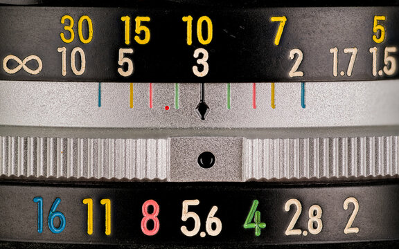 Close up macro photograph of the aperture and focus dials on a vintage lens