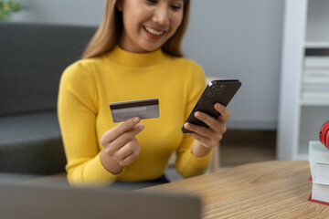 Asian businesswoman shopping online on mobile with credit card for convenient spending at home on vacation, online banking banking, e commerce virtual shopping, secure mobile banking concept.