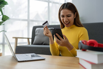Asian businesswoman shopping online on mobile with credit card for convenient spending at home on vacation, online banking banking, e commerce virtual shopping, secure mobile banking concept.