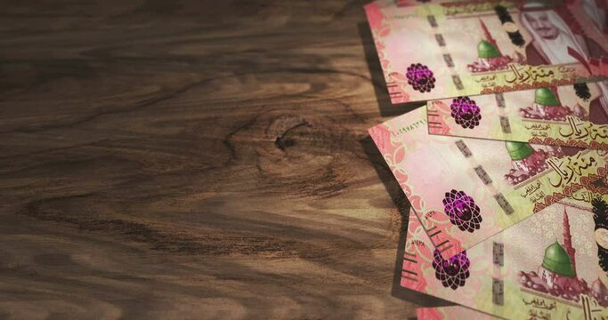 Saudi Arabia Rial 100 SAR banknotes on the wooden table. Saudi Arabia currency paper notes 3D concept background. Seamless and looped.