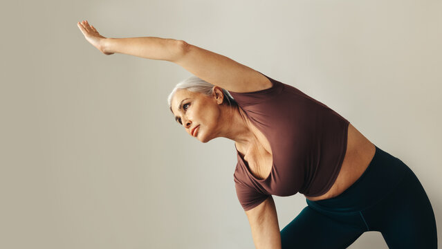Mature woman doing the extended side angle pose during a yoga workout