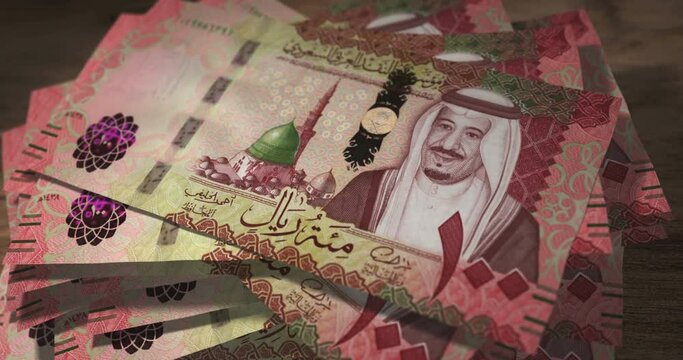 Saudi Arabia Rial 100 SAR banknotes falling on the table. Saudi Arabia currency paper notes count on stack. Timelapse of money counting. 3D concept.