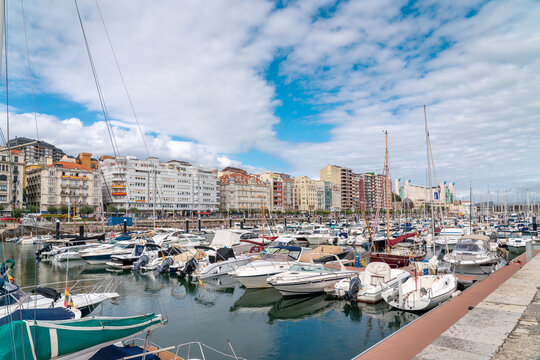 Santander, SPAIN - August 21 2022: Beautiful marina of Santander. Boats, yachts docked in the port. Travel destination in North of Spain. Panoramic view of marina and part of the city center. 