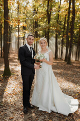 the bride and groom are dancing against the background of a fairy-tale fog in the forest. The rays...