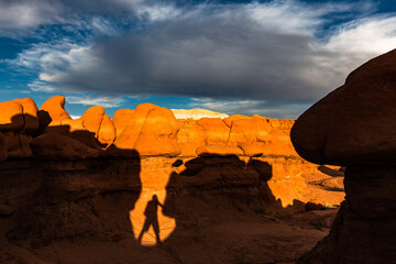 Rocky cliff at sunset, illuminated by the sun which creates large shadows. Goblin Valley State...