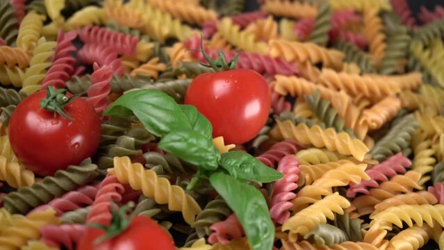 Ravvicinato di pomodori e basilico con pasta da cuocere