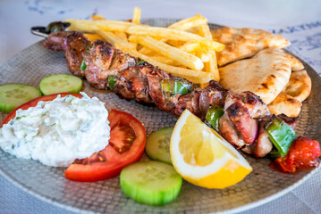 Greek pork Souvlaki with tzatziki sauce and fresh vegetables.