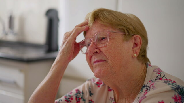 Pensive Close-Up of Senior Woman_s Face, Hand on Forehead, Reflecting on Thoughts. Worried Elderly Person in Her 80s ruminating past experiences
