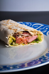 Delicious kebab with meat, lettuce, tomato, onion and sauce with french fries.