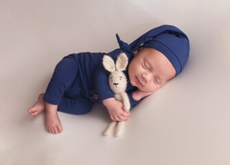 A newborn baby in a blue suit. The first photo session of a newborn.