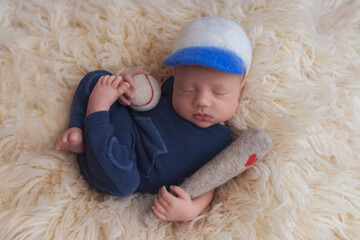Fototapeta premium Newborn baby in a blue bodysuit. The first shooting of the baby.