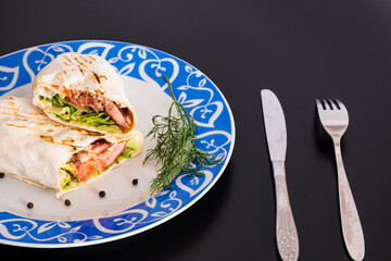 Delicious kebab with meat, lettuce, tomato, onion and sauce with french fries.