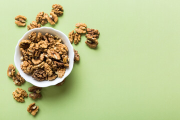 Fresh healthy walnuts in bowl on colored table background. Top view Healthy eating bertholletia concept. Super foods