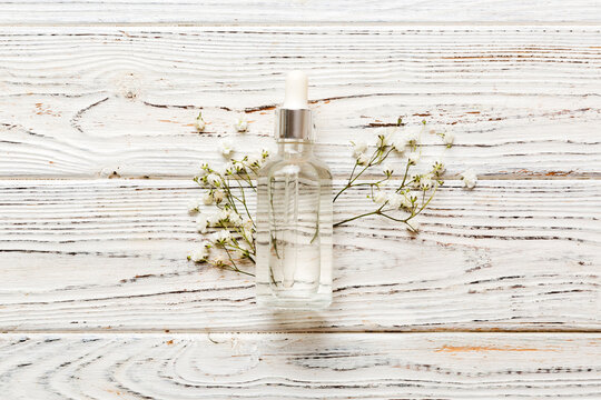 Fancy healthcare bottles for serum, micellar, tonic, toner, lotion, water and cream with gypsophila branch. Natural oranic spa cosmetics concept. Mockup, template, Top view