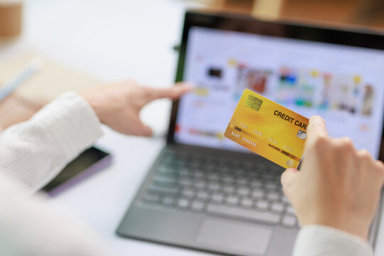 Concept of Online shopping, e-commerce, Woman holding credit card and using laptop computer for shopping online,Businesswoman paying for goods or services using credit card through online channels