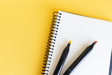 notebook and markers on the yellow background