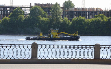 A yellow tugboat floats on the river, Neva River, Saint Petersburg, Russia, June 12, 2023