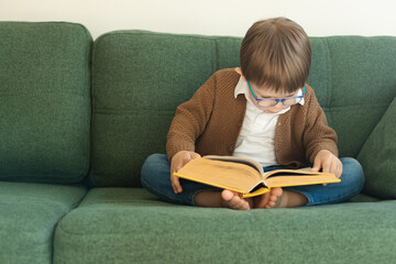 little boy with glasses reading a book