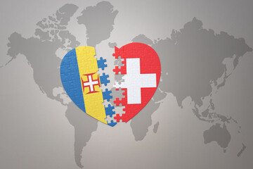 Fototapeta premium puzzle heart with the national flag of switzerland and madeira on a world map background. Concept.