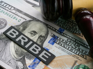 Cash with a gavel and the inscription bribe on them.