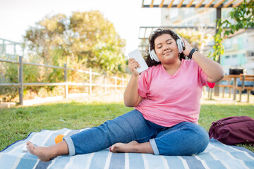 Happy Latin Woman Listening Music With Headphones And Smartphone Outside