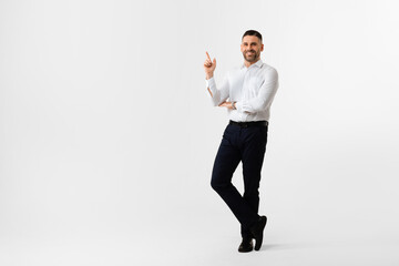 Business ad. Cheerful businessman pointing aside at copy space, demonstrating free place for...