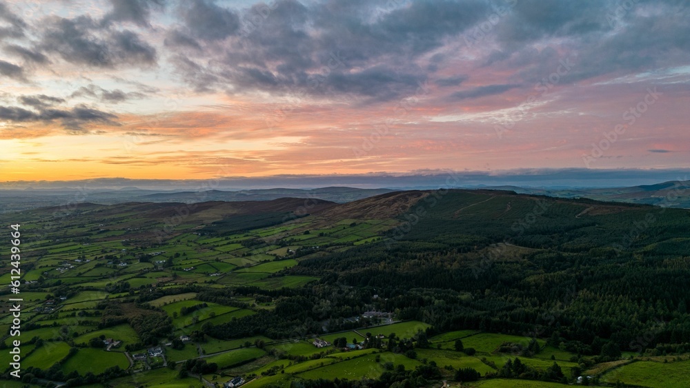 Poster aerial view of greenery fields with dense trees during sunset