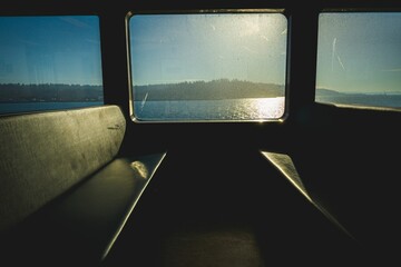 Beautiful shot of empty seats and a sightseeing view from a window of a ferry