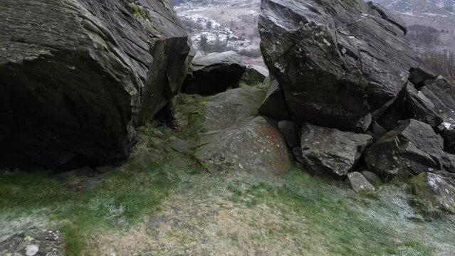 Drone shot going through rocks and showing Capel Curig lake in a cold atmosphere