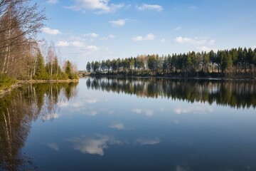 Fototapeta na wymiar Beautiful natural view of a lake with a reflection of the sky and a forest