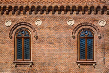 Close-up shot of cross hatch styled windows on a brick building in Krakow, Poland
