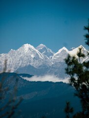 Vertical shot of the Himalayas peaks covered in snow with a blue sky in the background, in Asia © Taguas Dhyay/Wirestock Creators