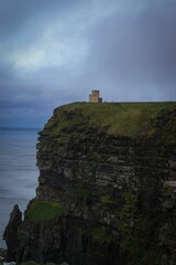 Vertical shot of the building on the cliff against a cloudy sky