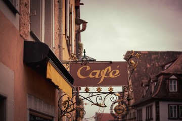 Vintage shot of a Cafe, coffee shop sign with a beautiful metalwork design in street in Rothenberg