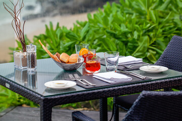 Enjoy a romantic dinner on beach with breathtaking ocean views. Table is beautifully set at a seafront restaurant in Phuket, offering luxurious and memorable dining experience.