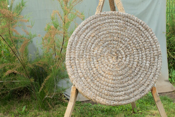 A woven rope target board for archery or darts outdoors.